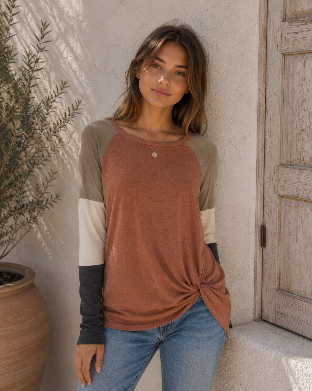 Front view of the Long Sleeve Colorblock Twist Front Top in Cinnamon featuring a twist hem and colorblock raglan sleeves.