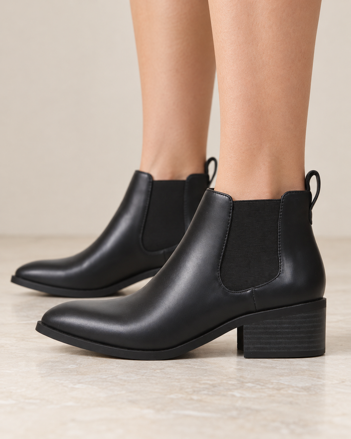 Black BC Footwear Partner Chelsea ankle boots worn on feet, side view