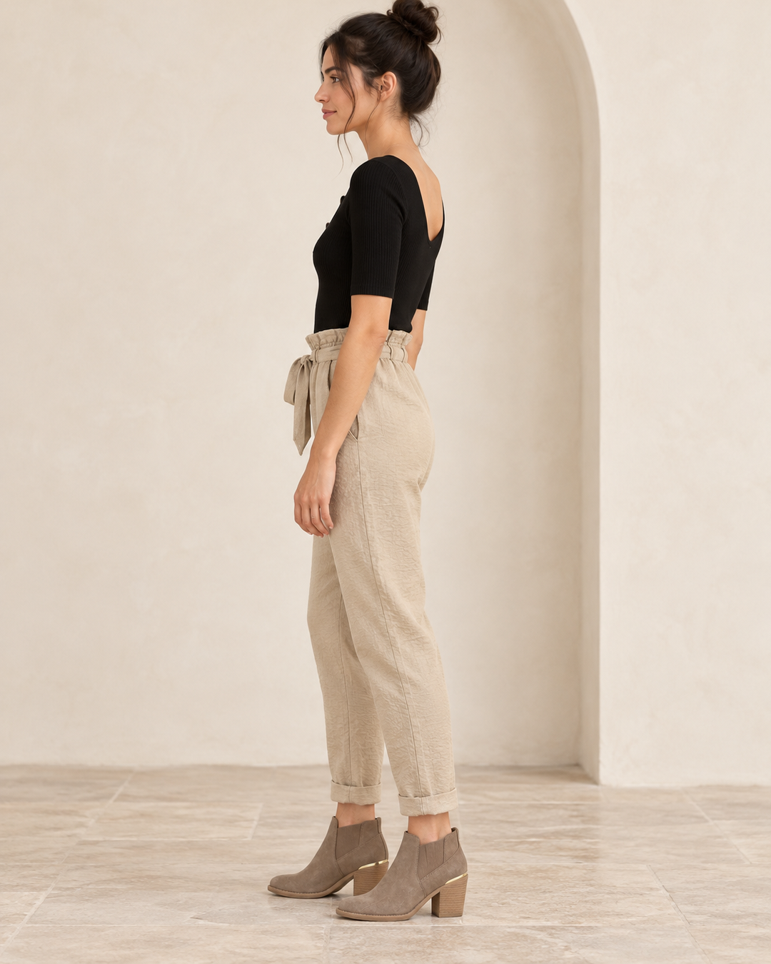 Wishlist Beatrice black ribbed button-front bodysuit, side view on a model styled with beige linen pants and taupe ankle boots. 