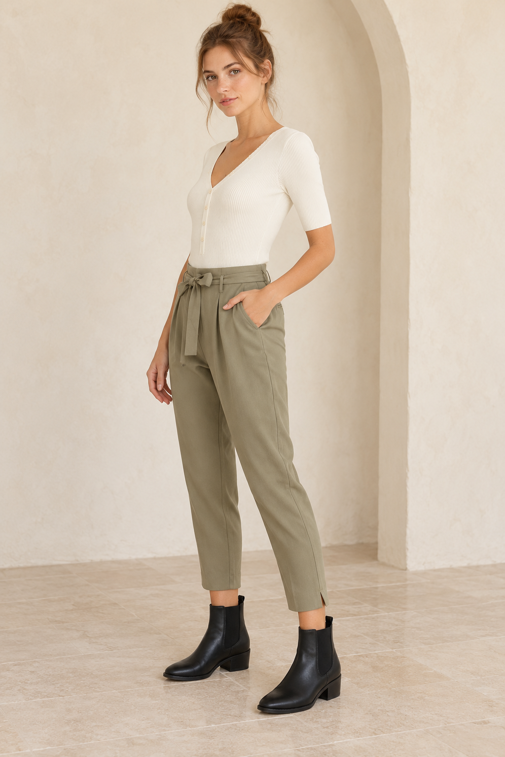 Wishlist Beatrice cream ribbed button-front bodysuit, side view on a model styled with olive tie-waist crepe pants and black Chelsea ankle boots. 