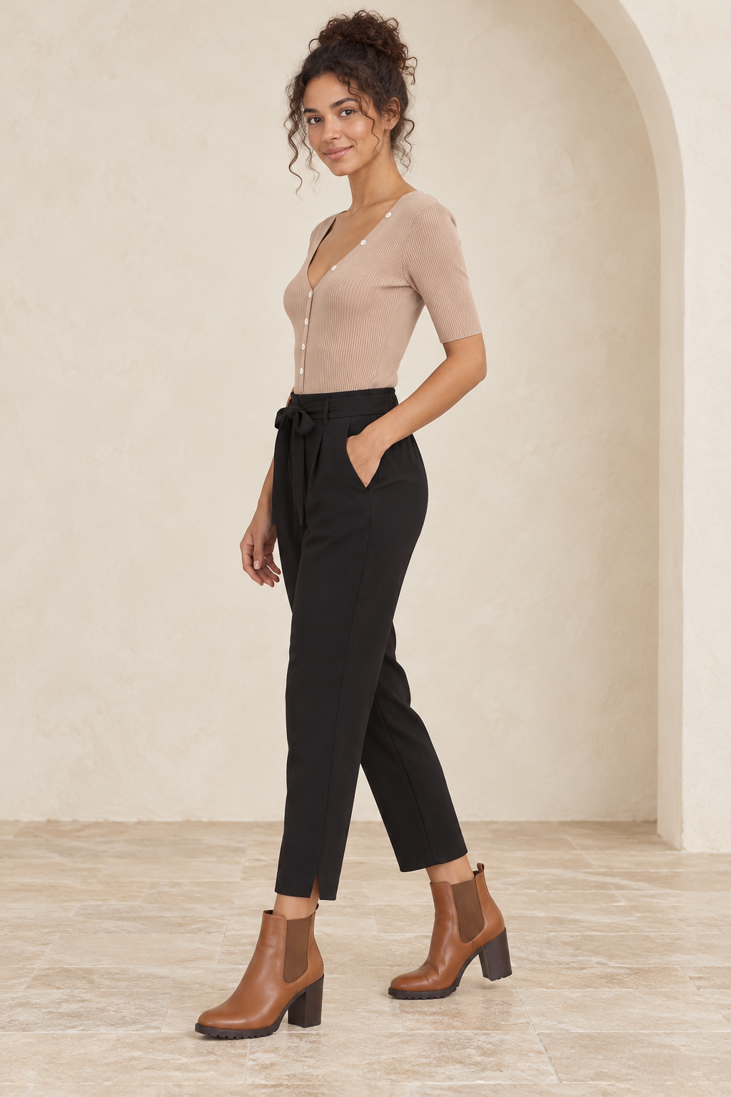 Wishlist Beatrice taupe ribbed button-front bodysuit, side view on a model styled with black crepe pants and camel Chelsea ankle boots. 