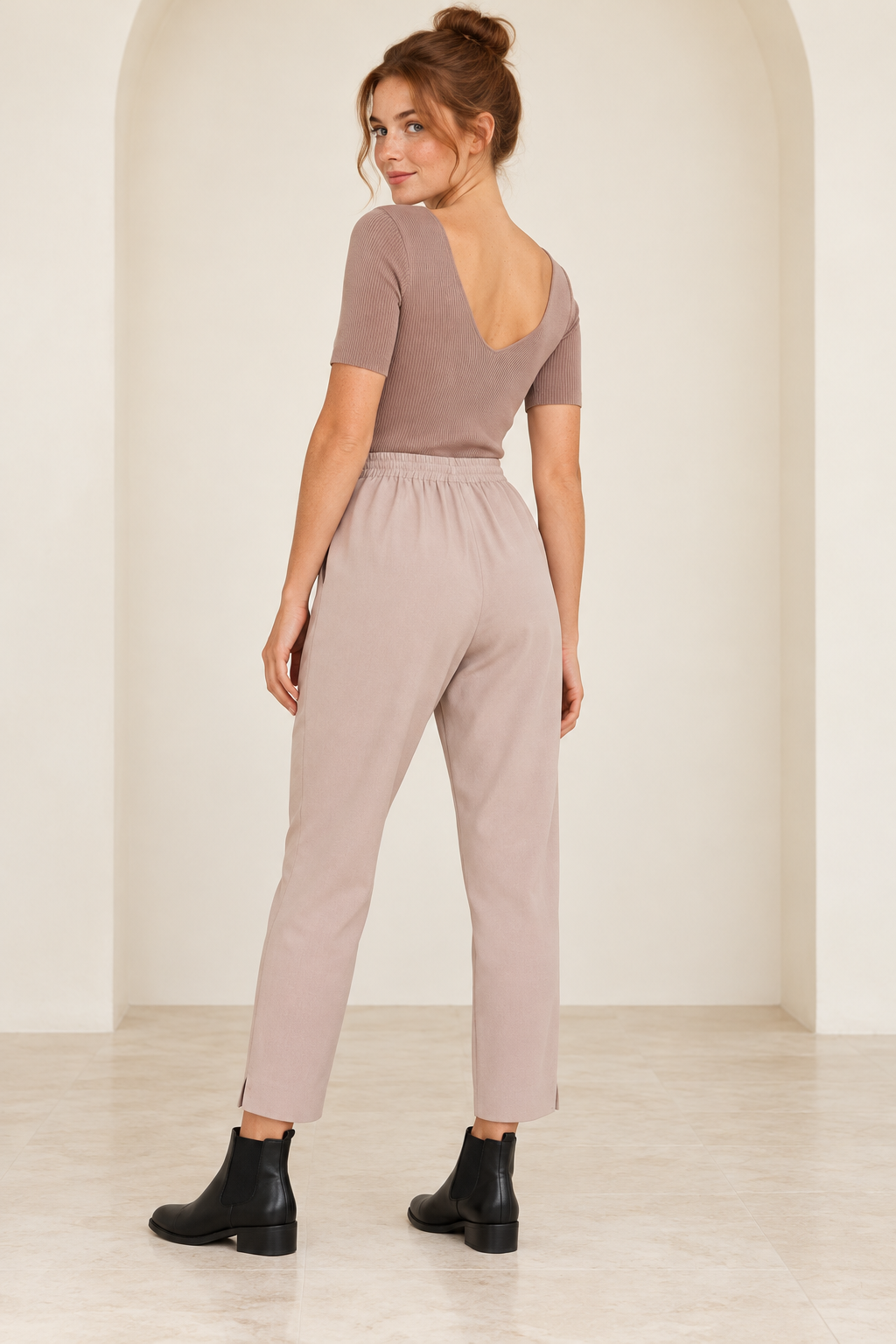 Wishlist Beatrice twig ribbed bodysuit, back view on a model showing the low rounded V-back with mauve crepe pants and black Chelsea ankle boots. 