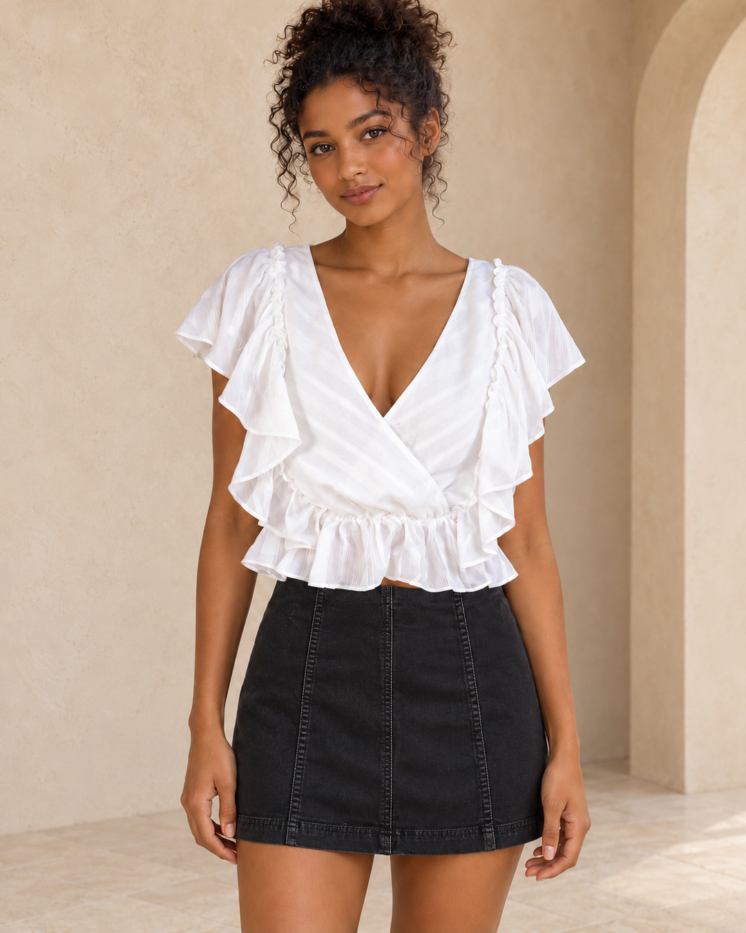 Follow Me ivory surplice top, close front view showing flutter ruffles and short peplum hem above a black Modern Femme mini skirt.