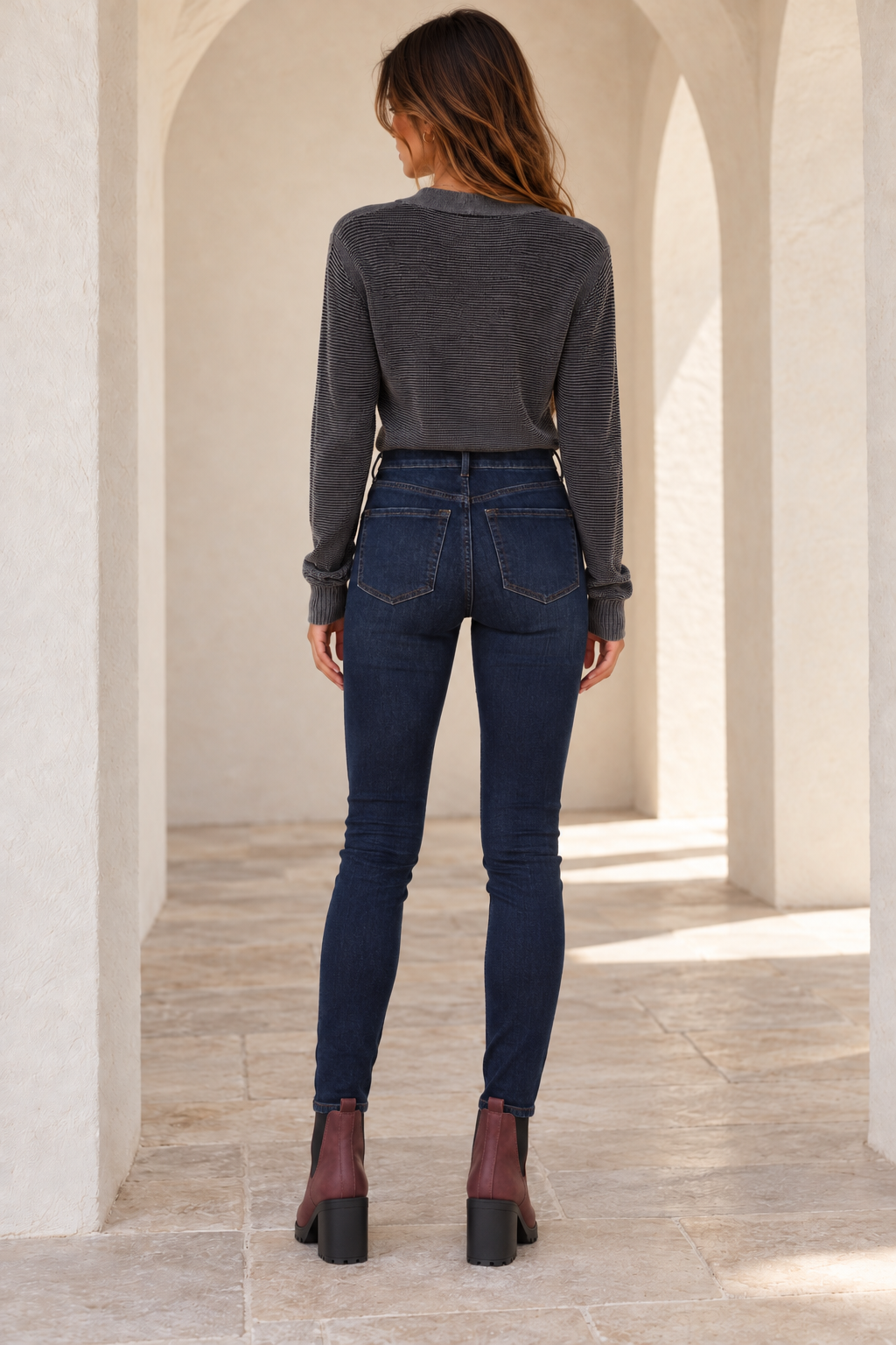Free People Busted dark-blue high-rise skinny jeans, back model view showing rear pockets and fitted legs