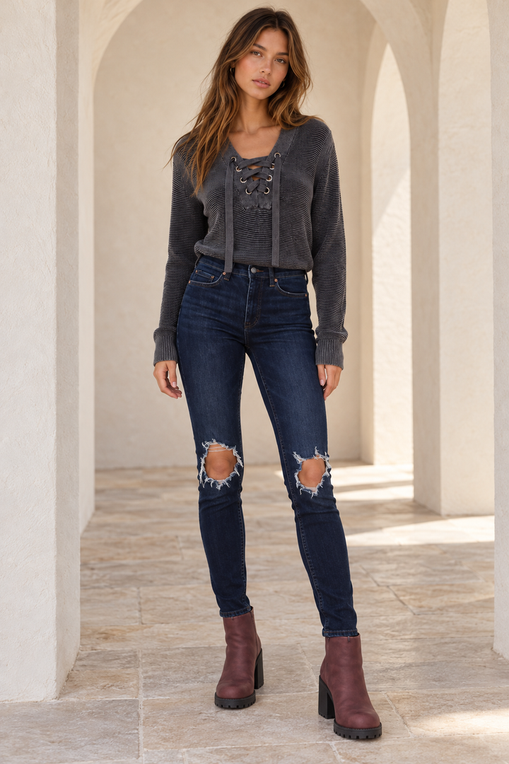 Free People Busted dark-blue high-rise skinny jeans, front model view showing ripped knees and close-fitting legs