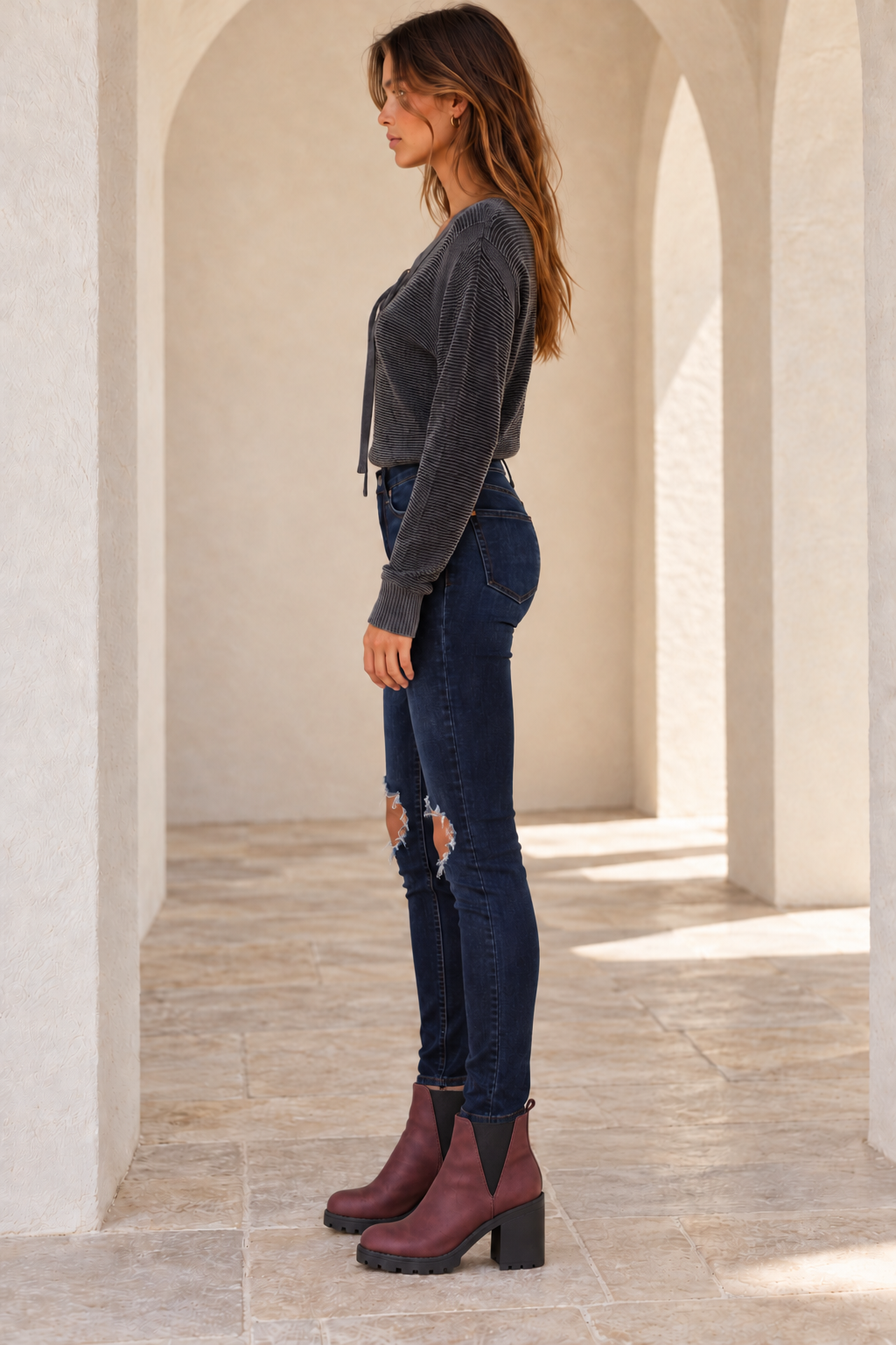 Free People Busted dark-blue skinny jeans, side model view showing high rise and slim ankle-length legs