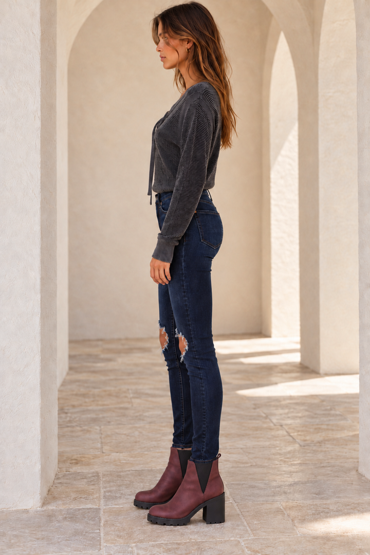 Free People Busted dark-blue skinny jeans, side model view showing high rise and slim ankle-length legs
