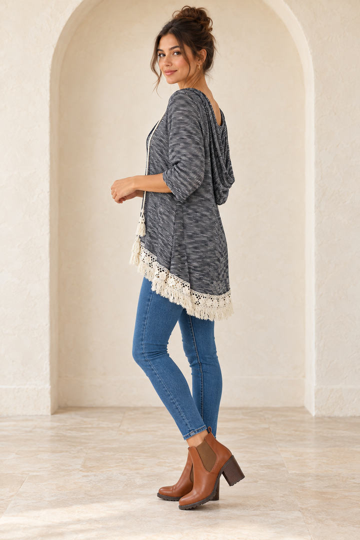 Grey two-tone hooded sweater tunic, side view on a model with medium-blue skinny jeans and camel Chelsea ankle boots.