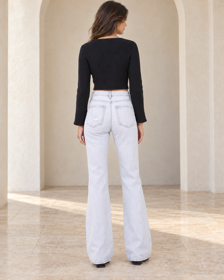 Back view of 90s Vintage Light Wash Flare Jeans, styled with the catalog black top and matching footwear.