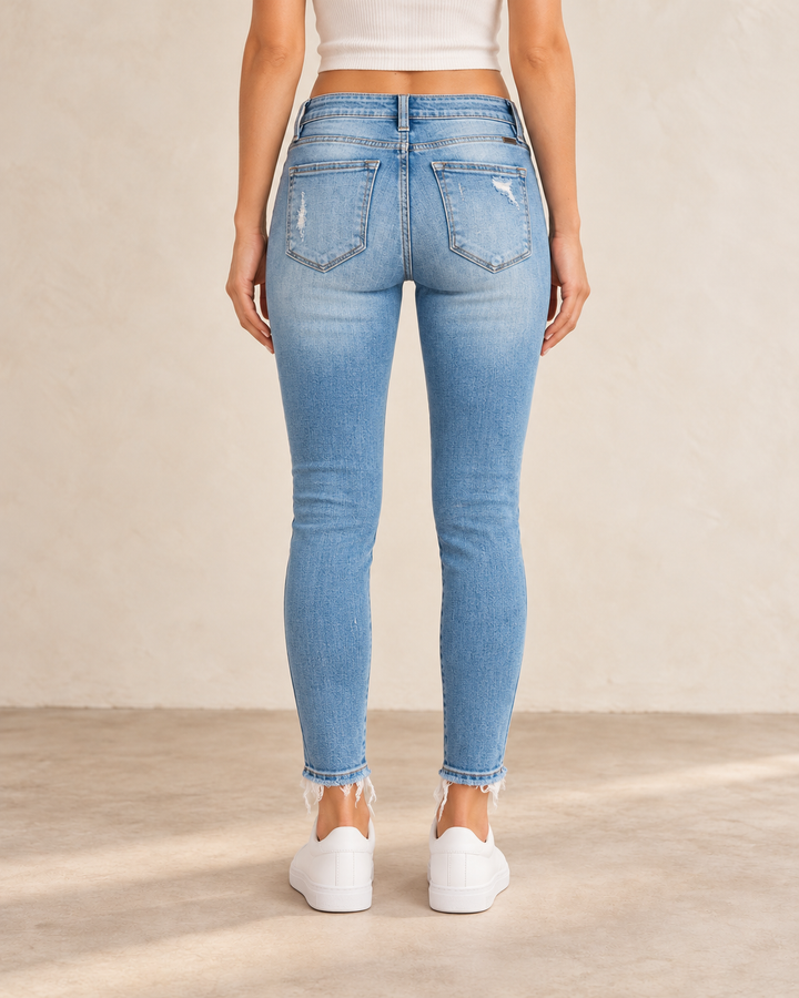 Back view of Lizzy distressed light-wash skinny jeans on a model, showing the back pockets and faded denim.