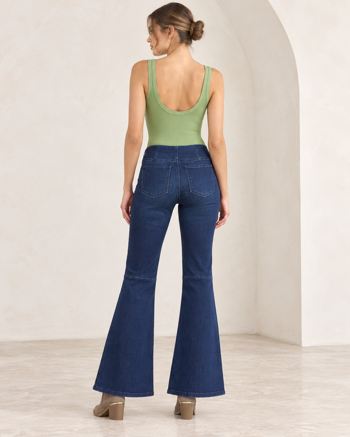 NikiBiki BASIL green ribbed scoop-neck and scoop-back bodysuit, back view on an adult model, styled with rich blue Free People Penny flare jeans and taupe Maude ankle boots. 