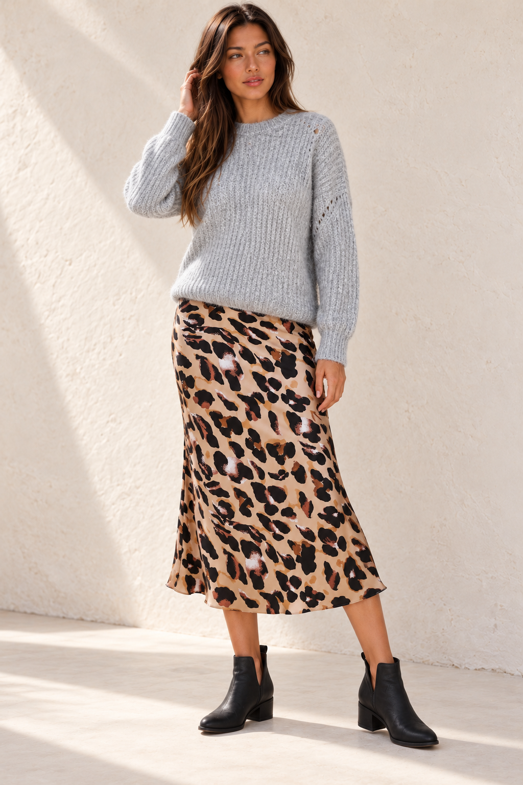 Christina grey knit sweater on a model with a leopard-print midi skirt and black Chelsea ankle boots.