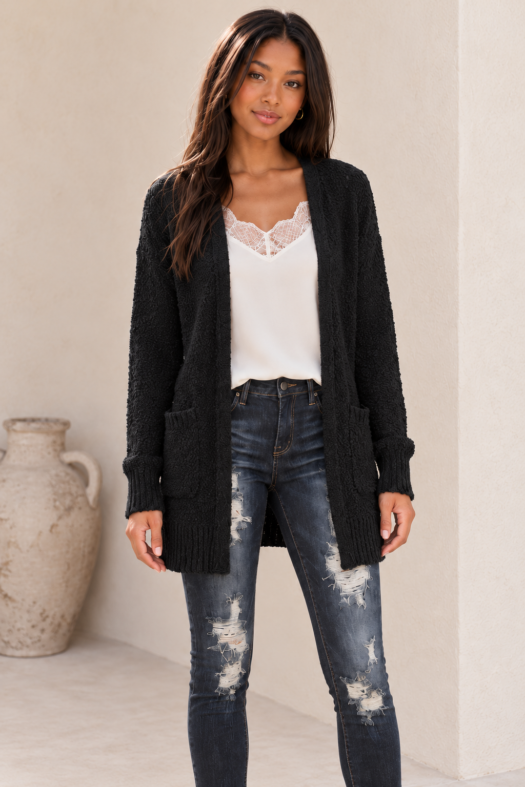 Closer view of the black fuzzy pocketed open-front cardigan showing the open edges, front pockets and complete hem.
