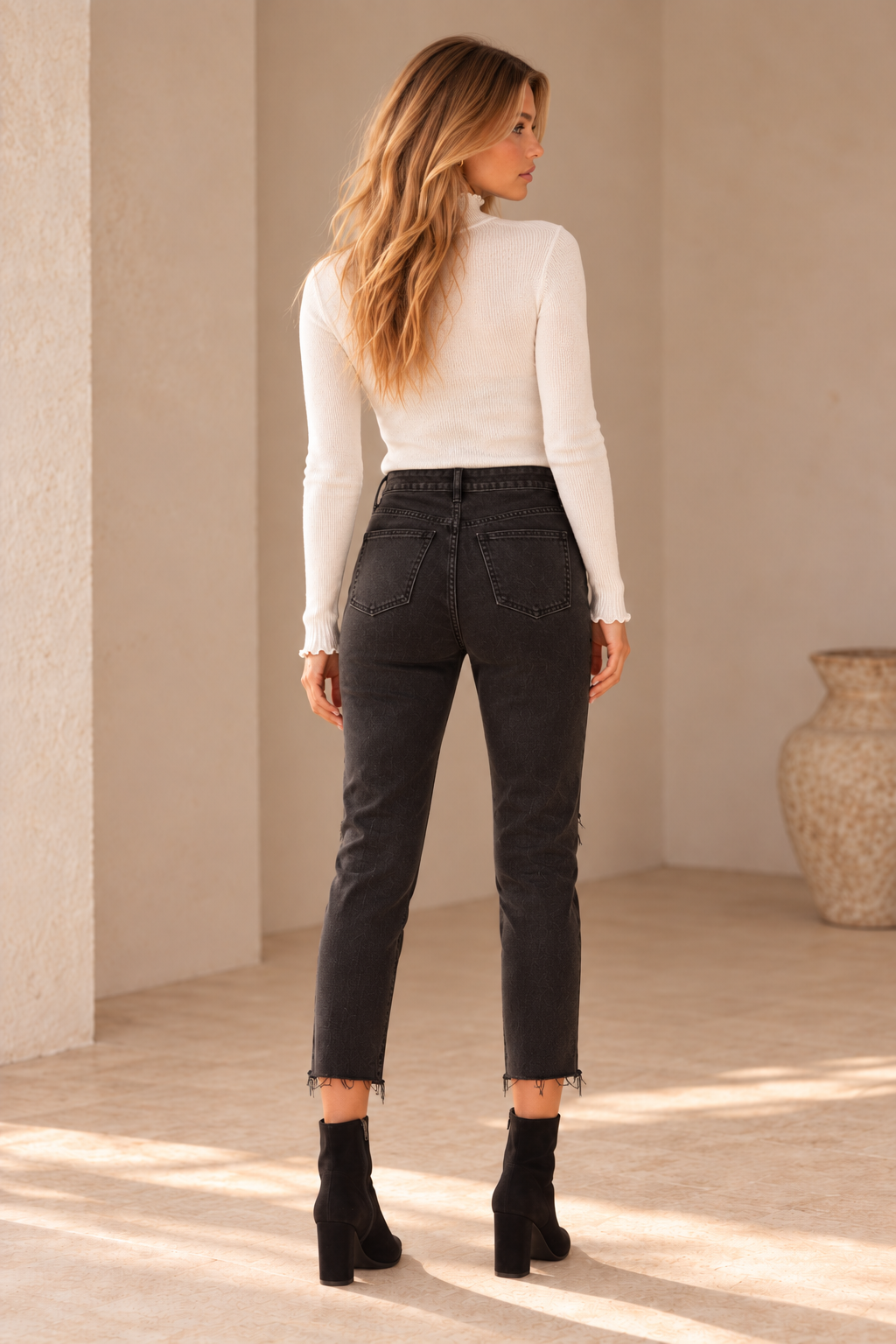 Free People Blossom Rigid Skinny Jeans in Day or Night Black, back view on an adult model in warm natural daylight.