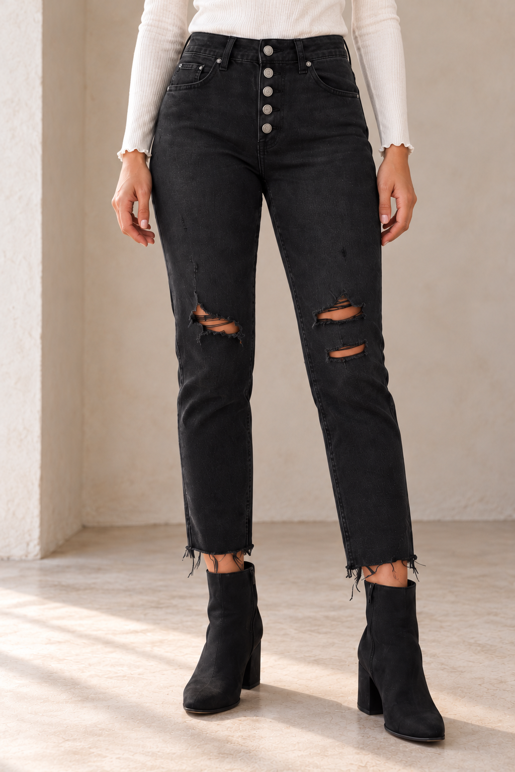 Free People Blossom Rigid Skinny Jeans in Day or Night Black, closer view on an adult model in warm natural daylight, showing the original denim construction with top and footwear.