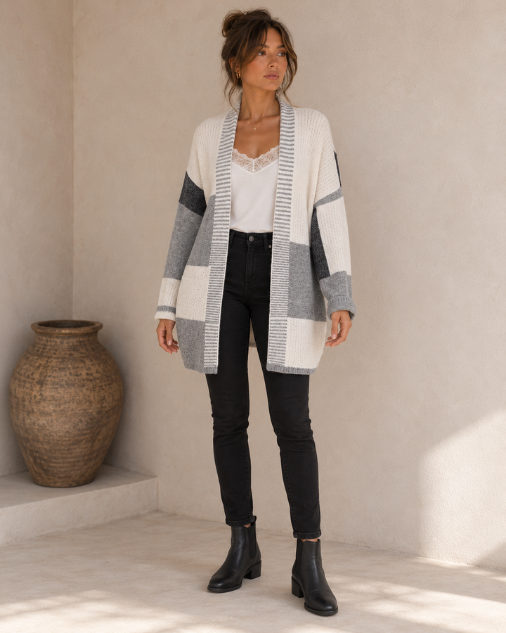 Front view of the greyscale longline open-front cardigan showing the striped edging, colorblock panels and loose sleeves.