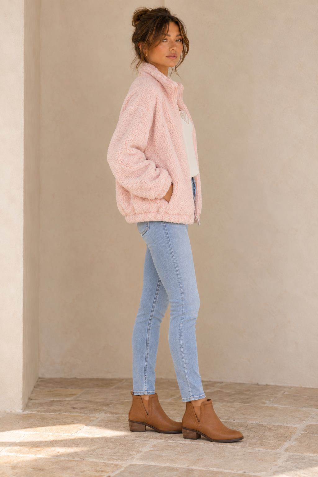 Side view of the Twig pale-pink zip-up teddy jacket showing the soft teddy texture and gathered hem.