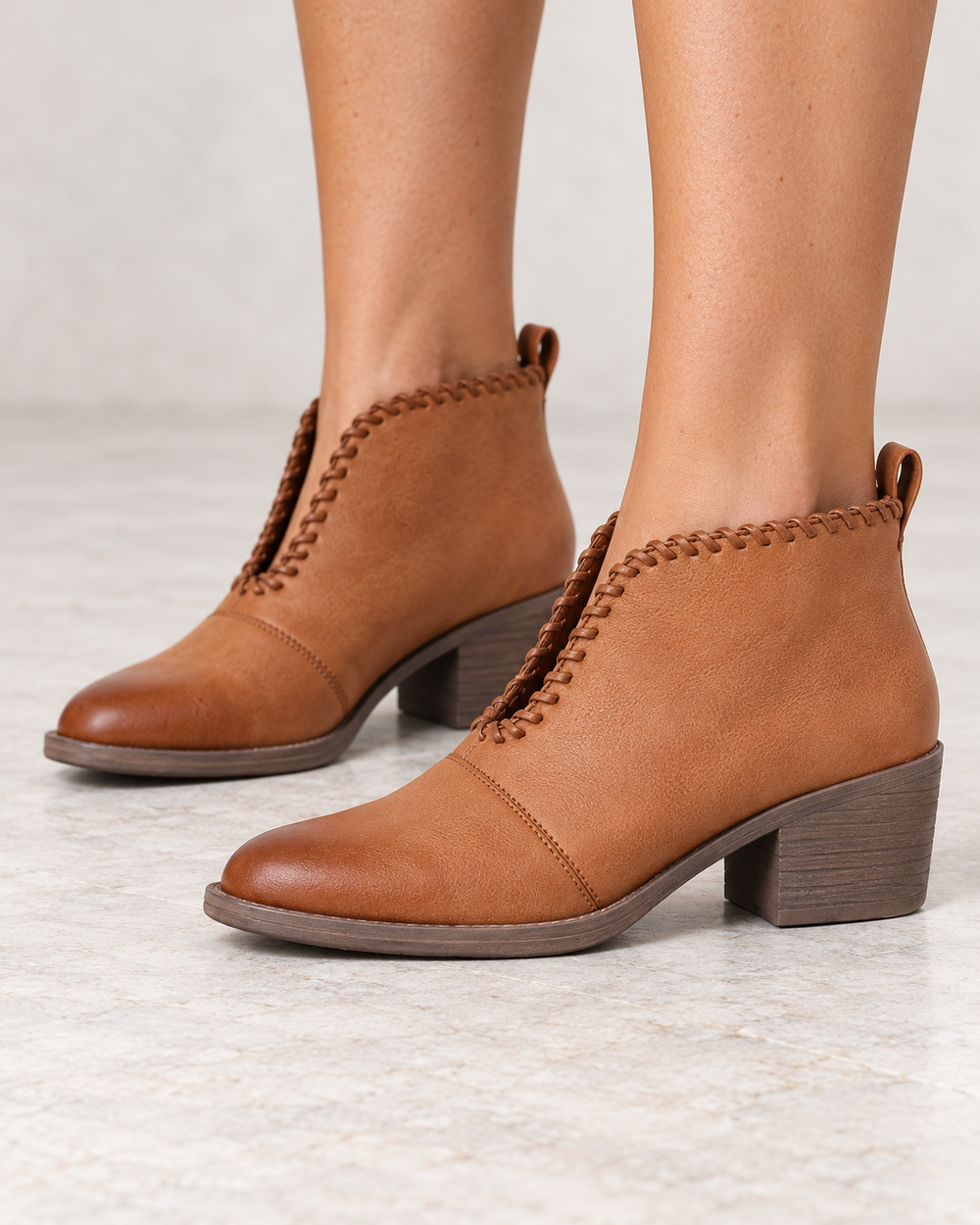 Very Volatile Cavalry tan ankle booties, modeled side view showing V-cut ankle openings and low heels
