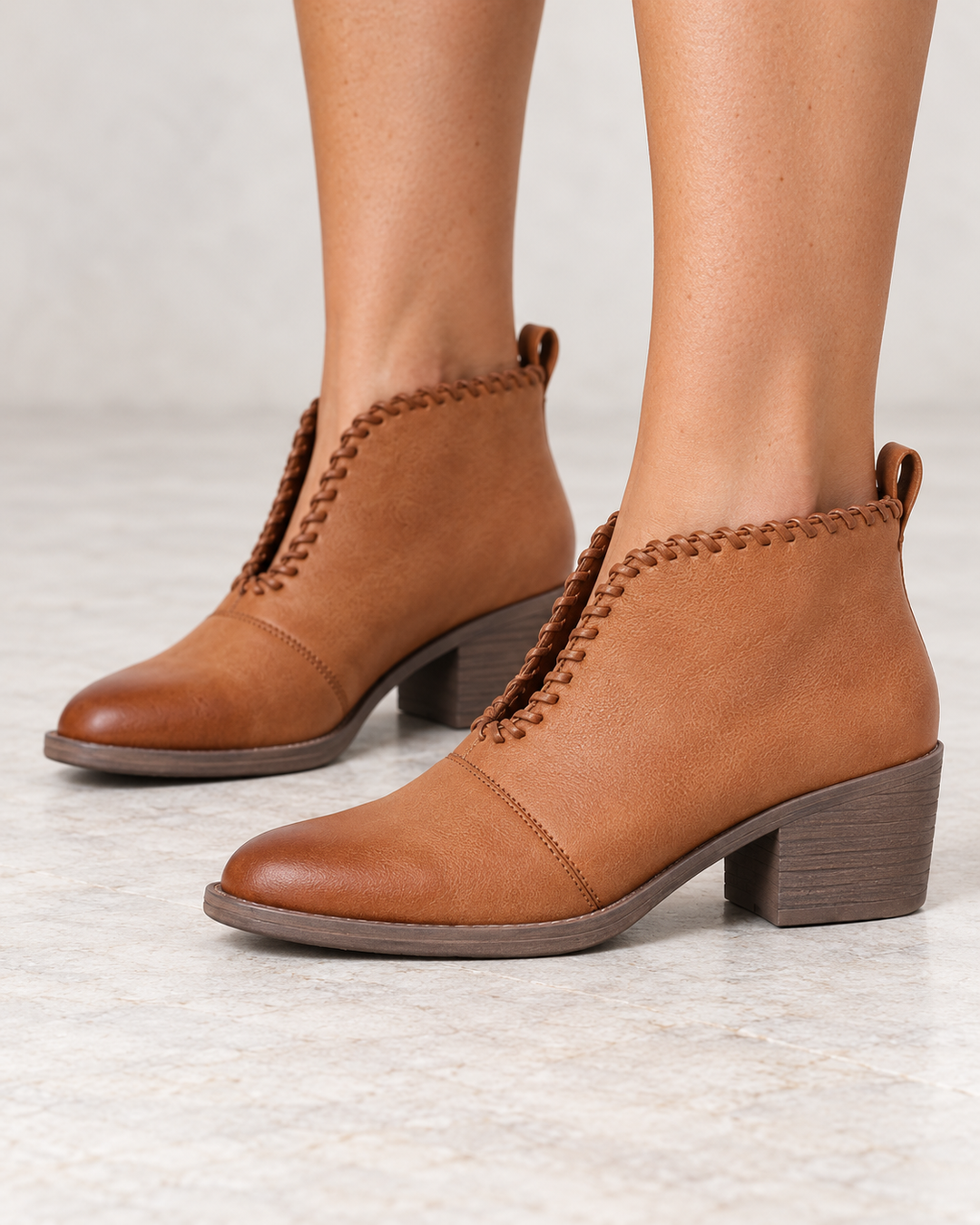 Very Volatile Cavalry tan ankle booties, modeled side view showing V-cut ankle openings and low heels