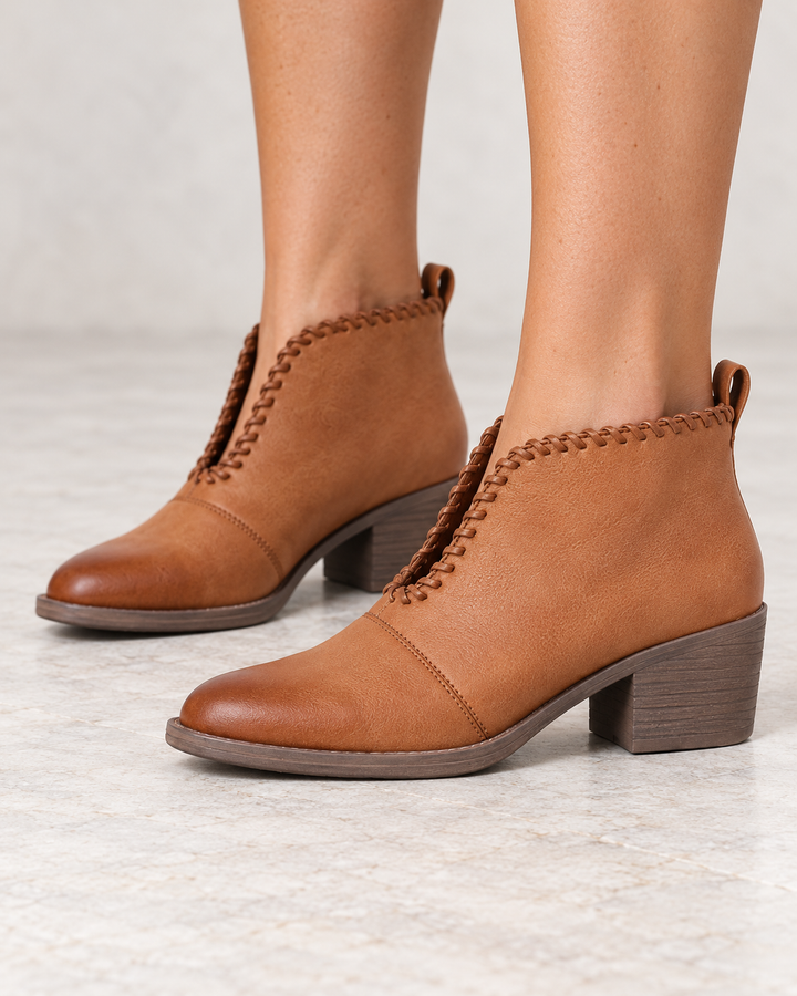 Very Volatile Cavalry tan ankle booties, modeled side view showing V-cut ankle openings and low heels