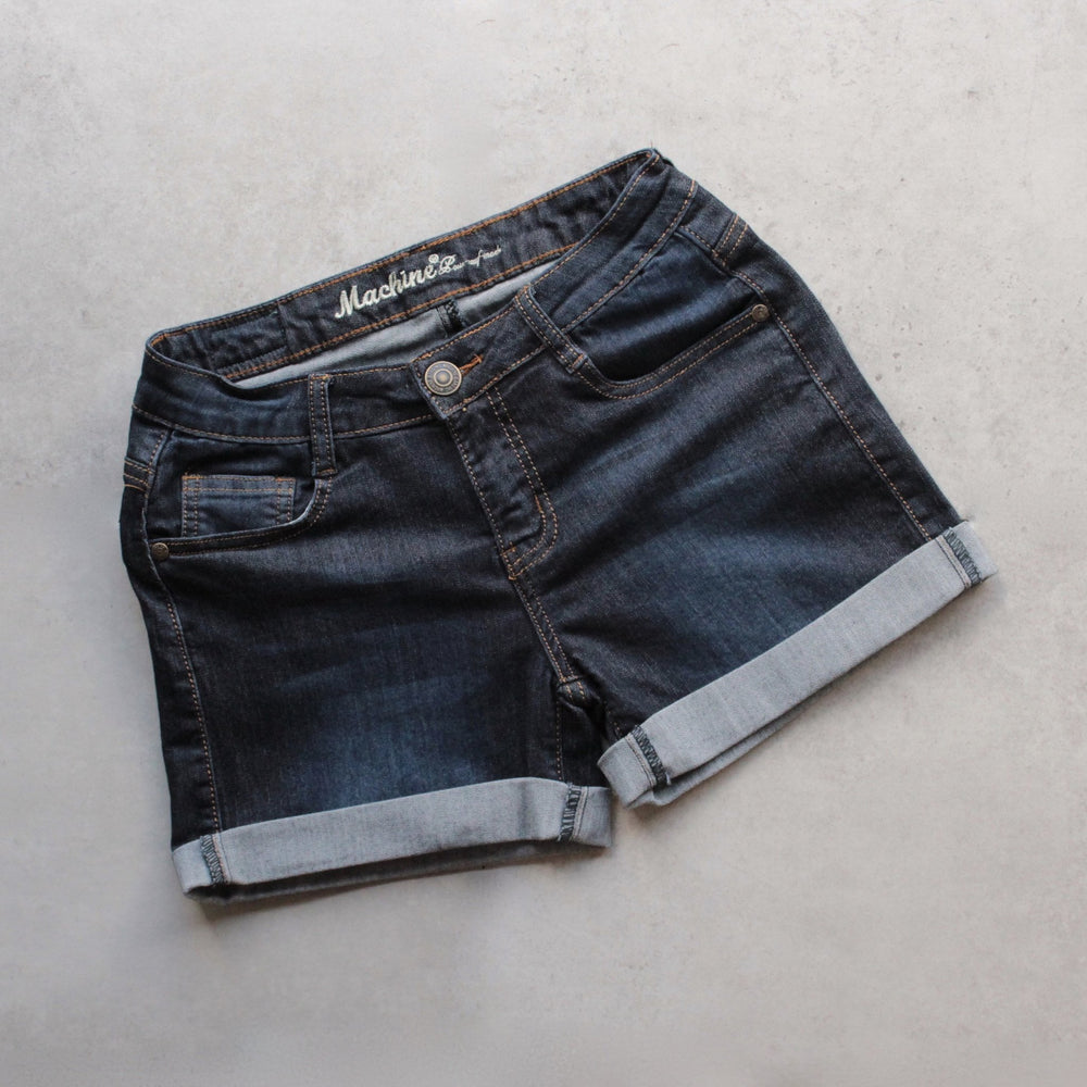 Dark-denim rolled-cuff shorts laid flat, front view showing button-and-fly closure, belt loops and pockets #color_dark-denim