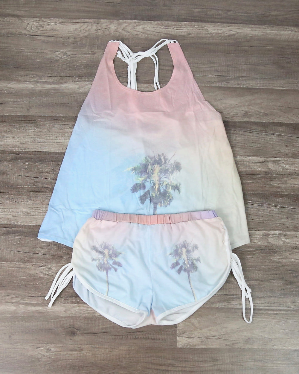 Palm-tree tie-dye loungewear separates, pastel tank and shorts laid flat together